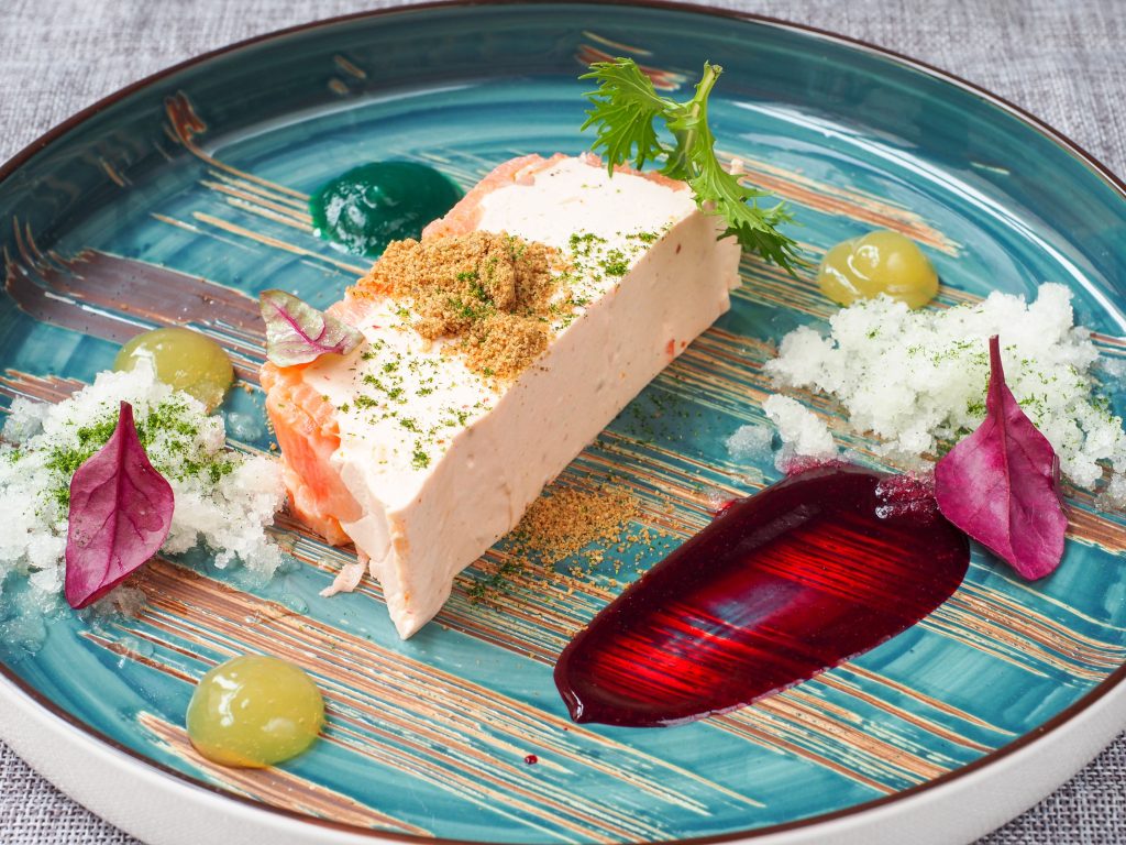 Stylish gourmet tofu dish on a decorated plate with vibrant sauces and garnishes.